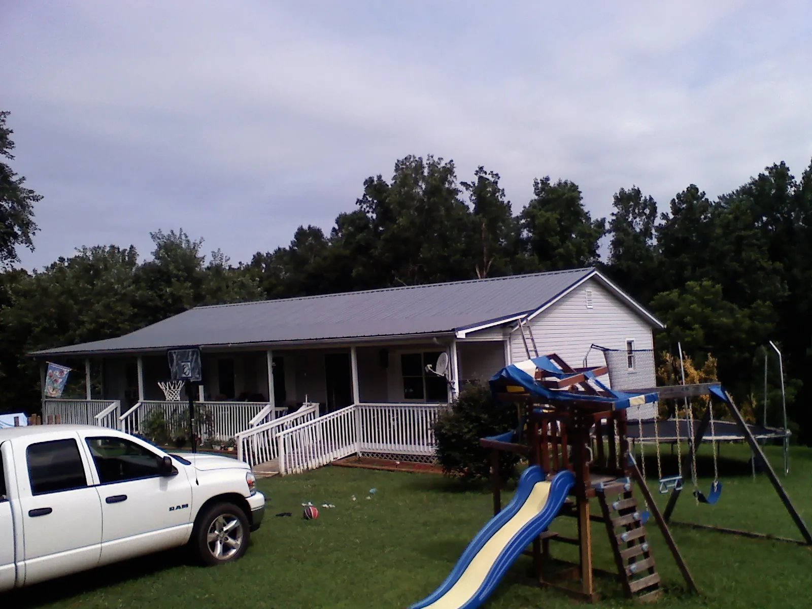 Dark metal roof on a country home with a full length front porch in Cornelius